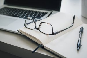 Okulary na książce przy laptopie